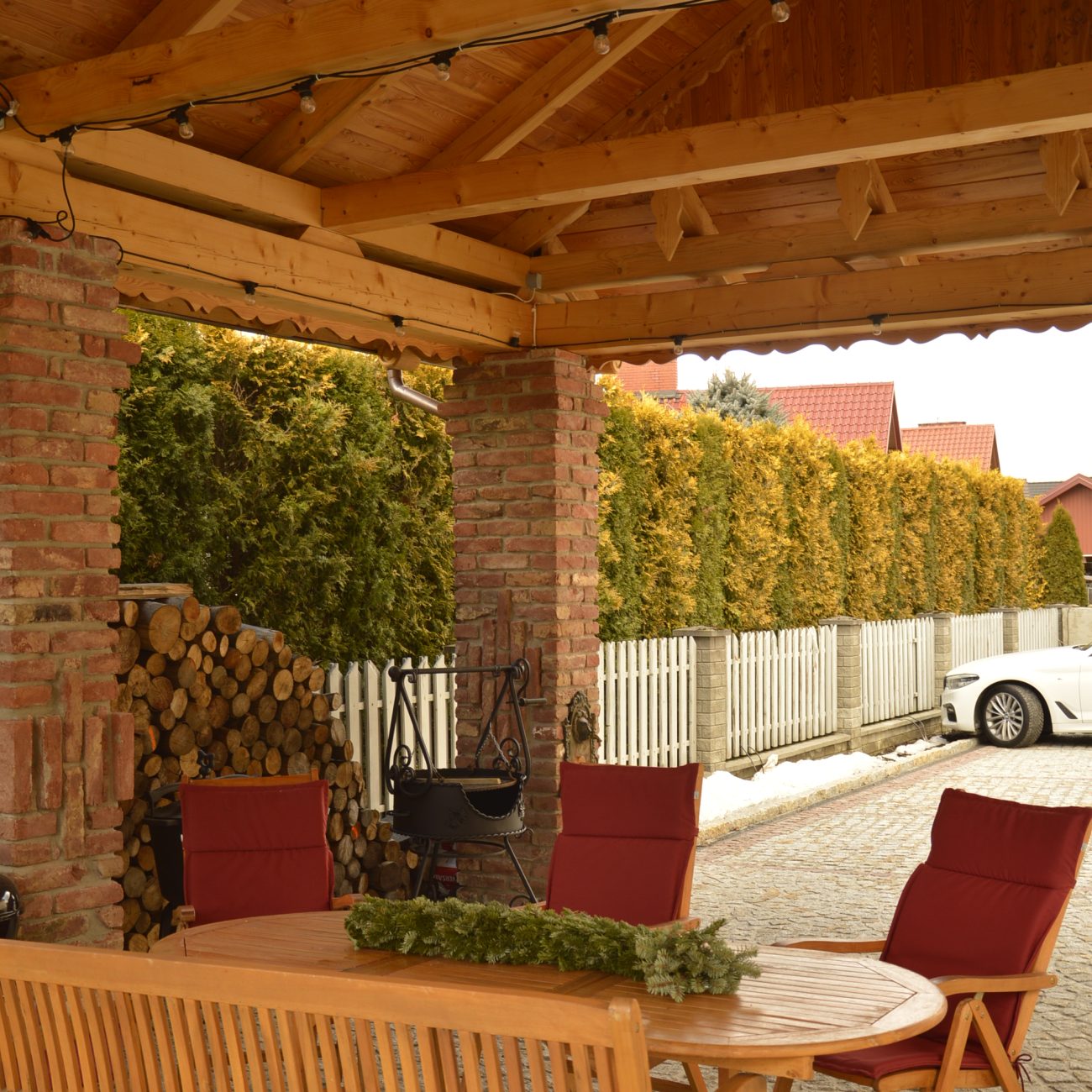 Altana z drewnianymi meblami i dekoracją z igieł sosny, Apartamenty Agroturystyczne Papiernia, rodzinna agroturystyka w górach