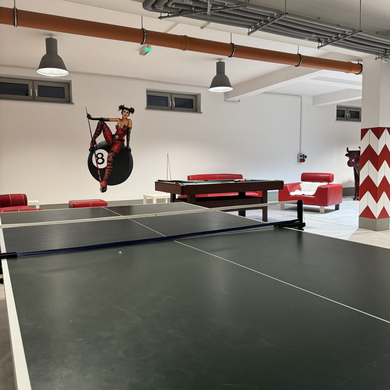 Pokój gier z tenisem stołowym, szaro-czerwone wykończenie, dekoracja grafitti na ścianie, czas ze znajomymi, noclegi w górach