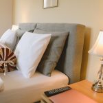 Przytulna sypialnia w apartamencie z wygodnym łóżkiem, poduszkami i stylową lampką nocną, klasyczny apartament, noclegi w górach Gorce