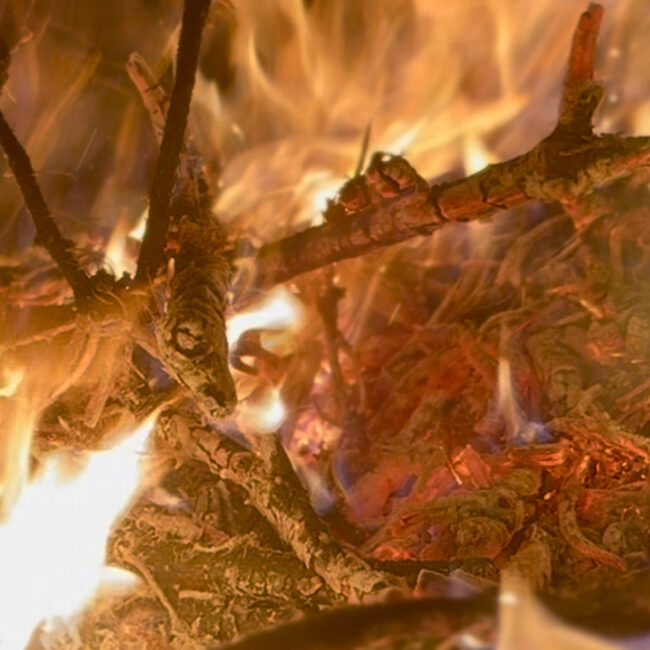 Palenisko z płonącym ogniem, doskonałe miejsce na wieczorne rozmowy w klimatycznej atmosferze. Romantyczny wypoczynek w górach