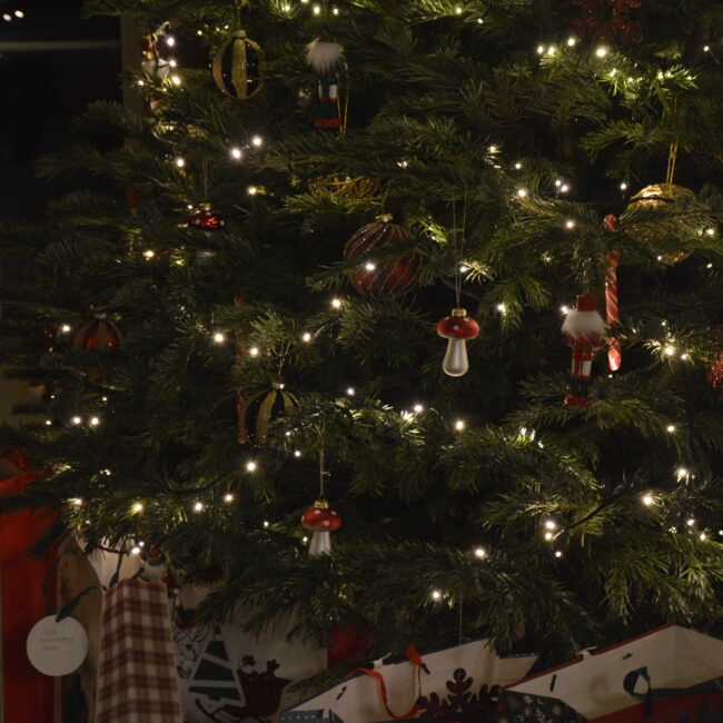 Urokliwa choinka przed agroturystyką w górach Gorce, otoczona śniegiem, podkreślająca atmosferę świąt, zimy i Sylwestra. Sylwester w górach Gorce